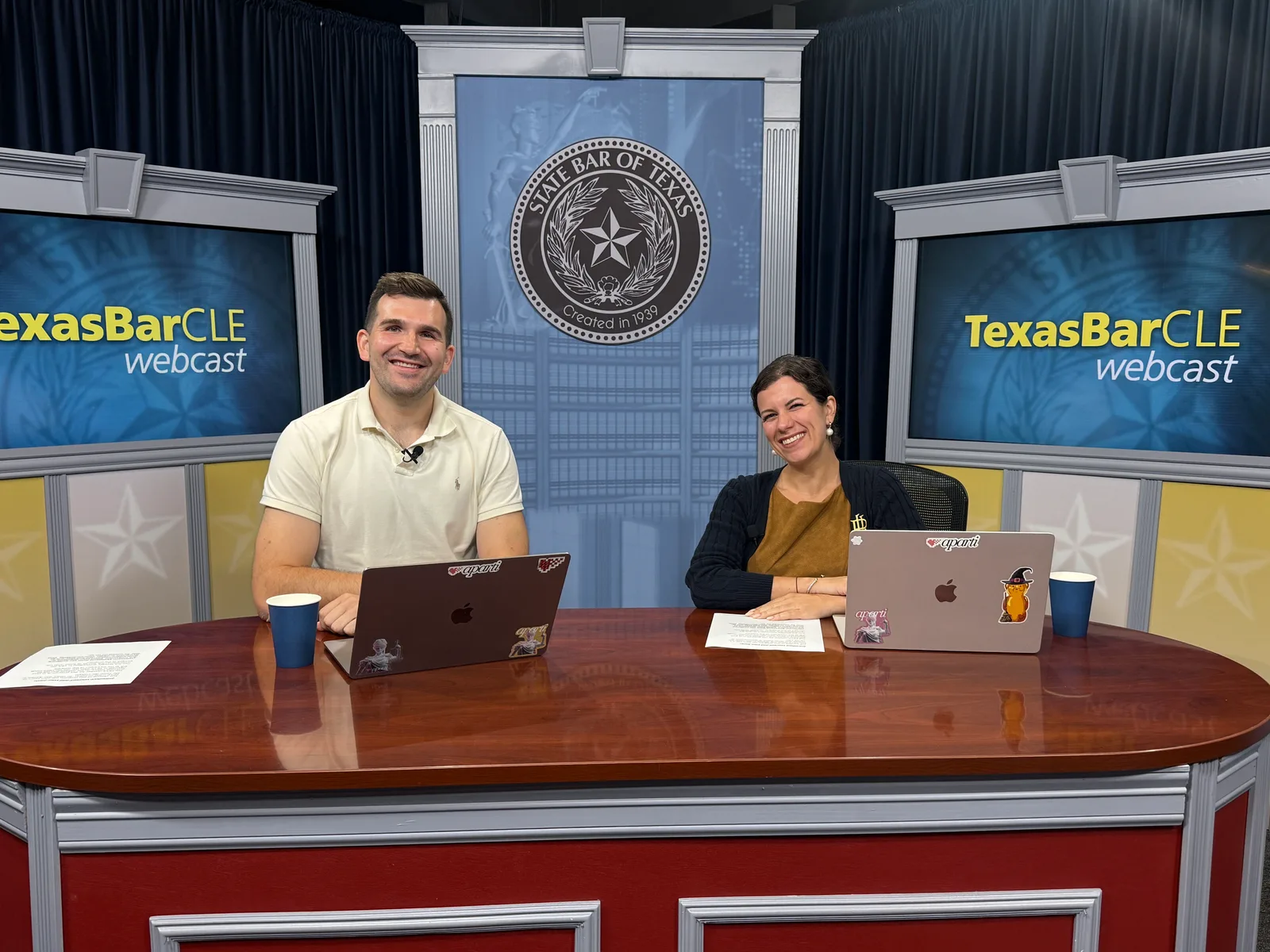 Two presenters seated behind laptops at the TexasBarCLE webcast desk, with the State Bar of Texas seal behind them.